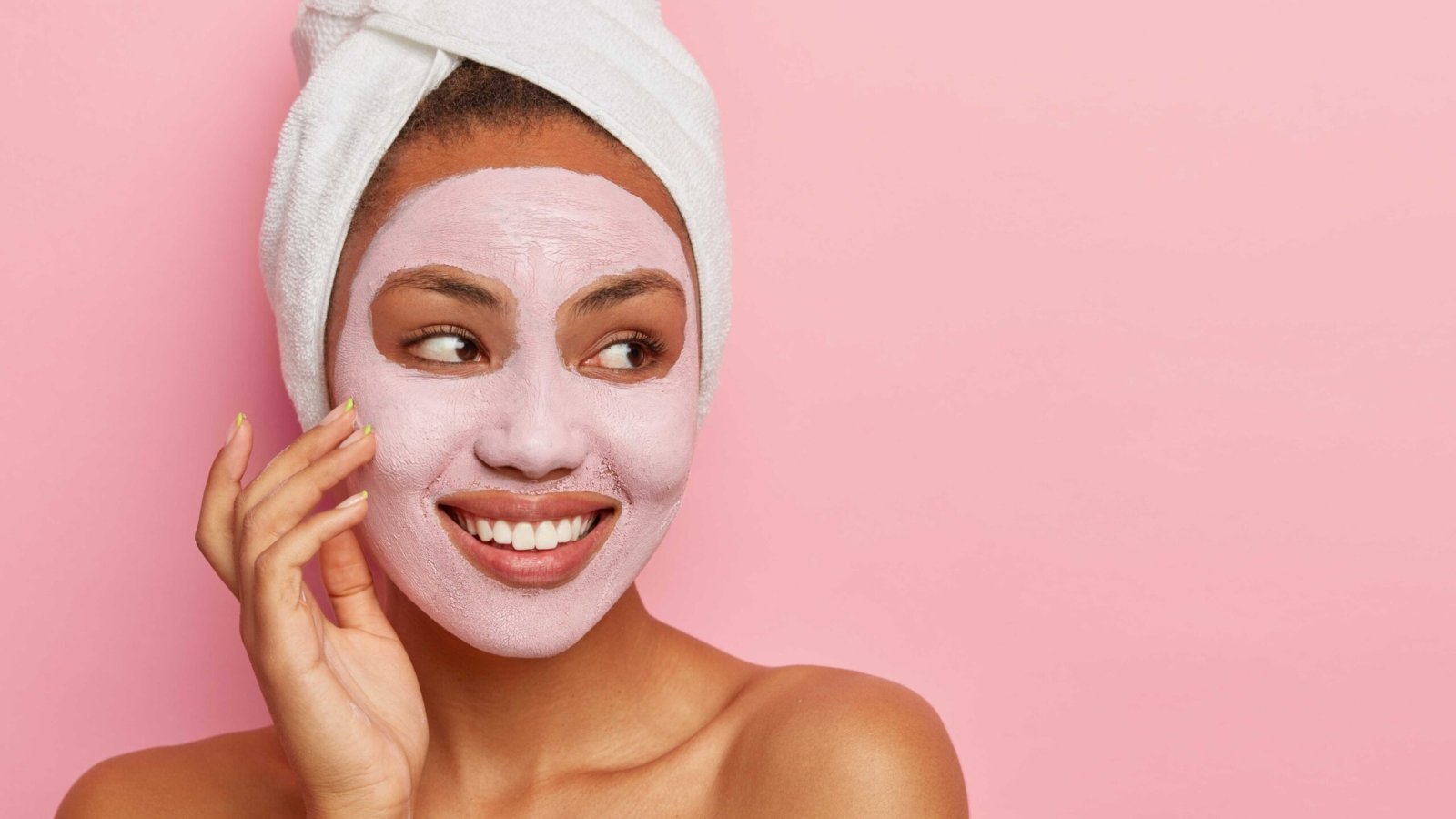 lovely-woman-has-delicate-sooth-skin-wears-cream-mask-face-reduce-acnes-has-healthy-complexion-hygienic-treatments-wears-white-wrapped-towel-head (1)